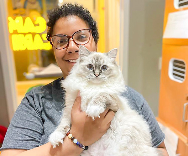 camp canine staff member holding a cat